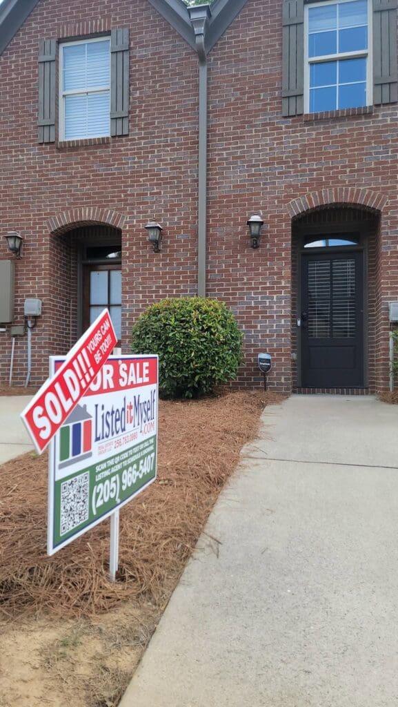 Flat fee MLS listing sign at a townhome entryway in Huntsville, AL, marked Sold by ListedItMyself.com